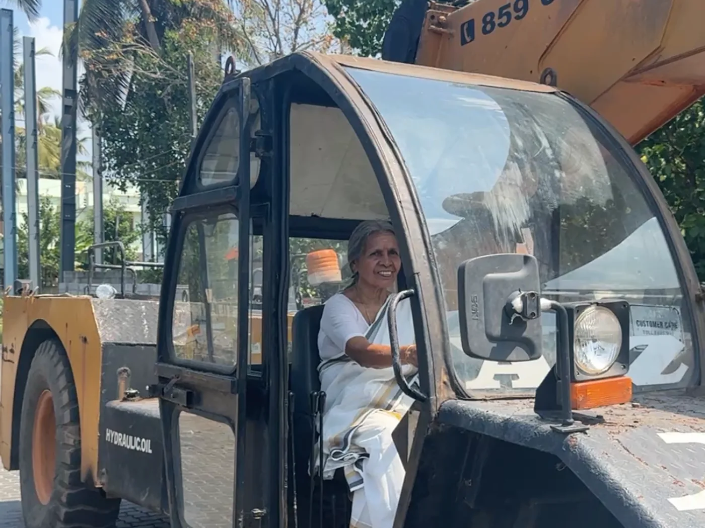 Radhamani Amma seated in the cab of a rough-terrain crane at A2Z Institute